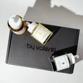 Three By Valenti serum bottles on a 'by valenti' branded box with a neutral background