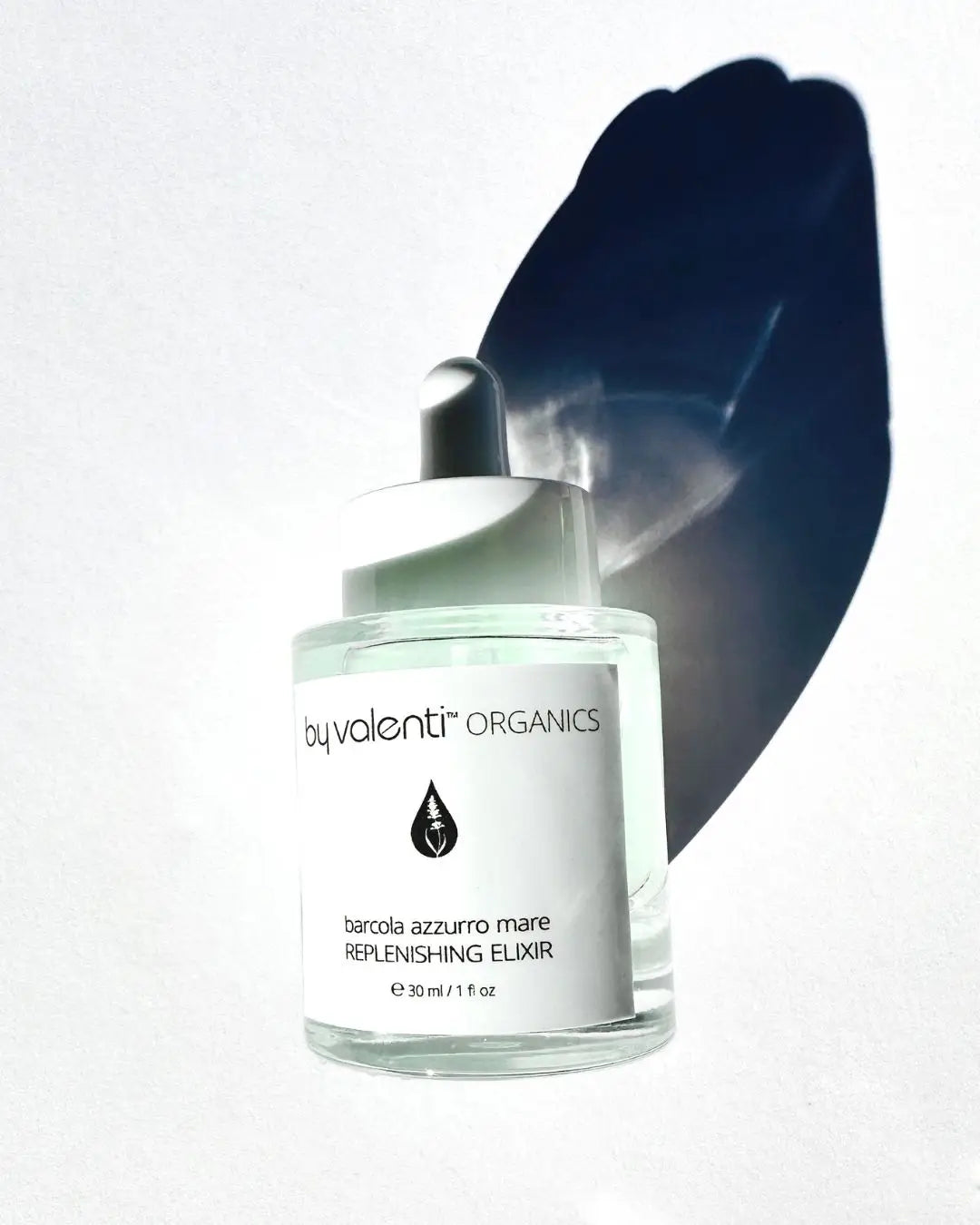 By Valenti Organics Barcola Azzurro Mare replenishing elixir bottle with a dark long afternoon shadow a white background
