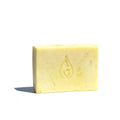By Valenti soft yellow Chamomile bar of soap with company's stamped logo on a white background