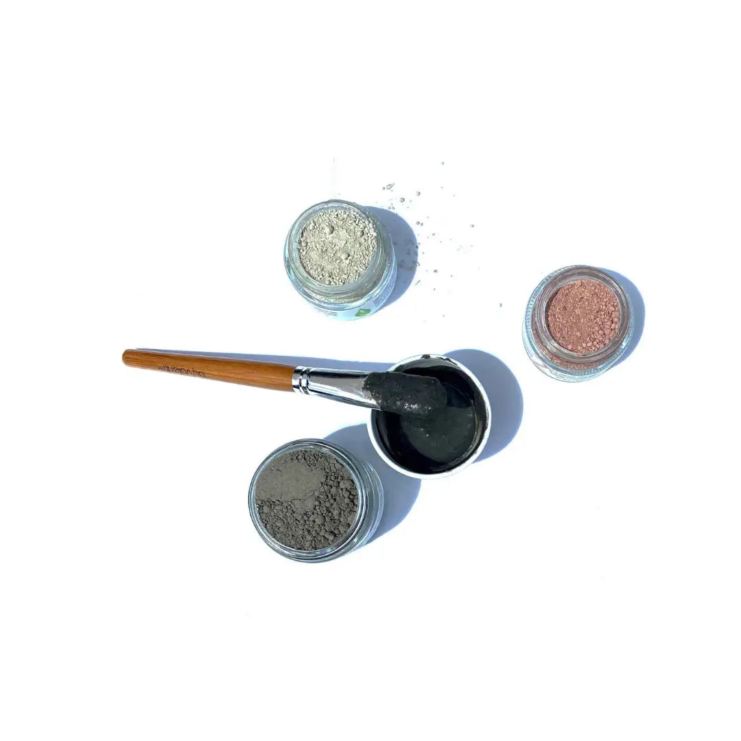 By Valenti set of red, green and black exfoliating clay masks with a small bowl with black mask and a brush