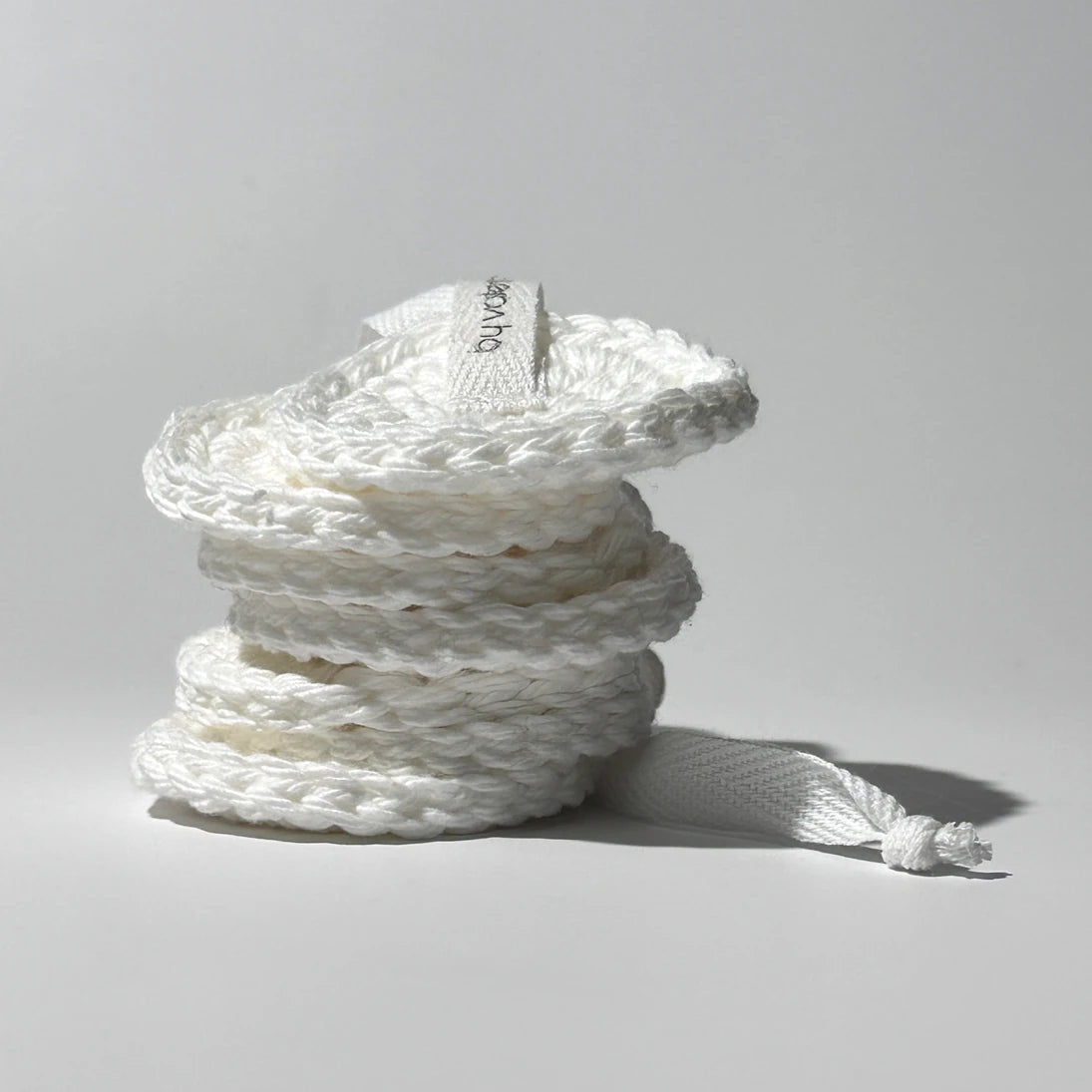 Stacked By Valenti set of 7 small white cotton facial cleansing pads on a light gray background