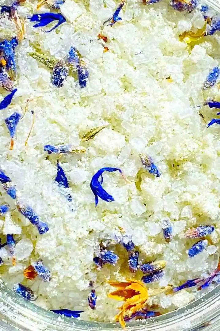 Close up of BY VALENTI milk bat salt with dried blue corn and yellow flowers