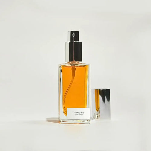 By Valenti perfume bottle with orange perfume on a light gray background
