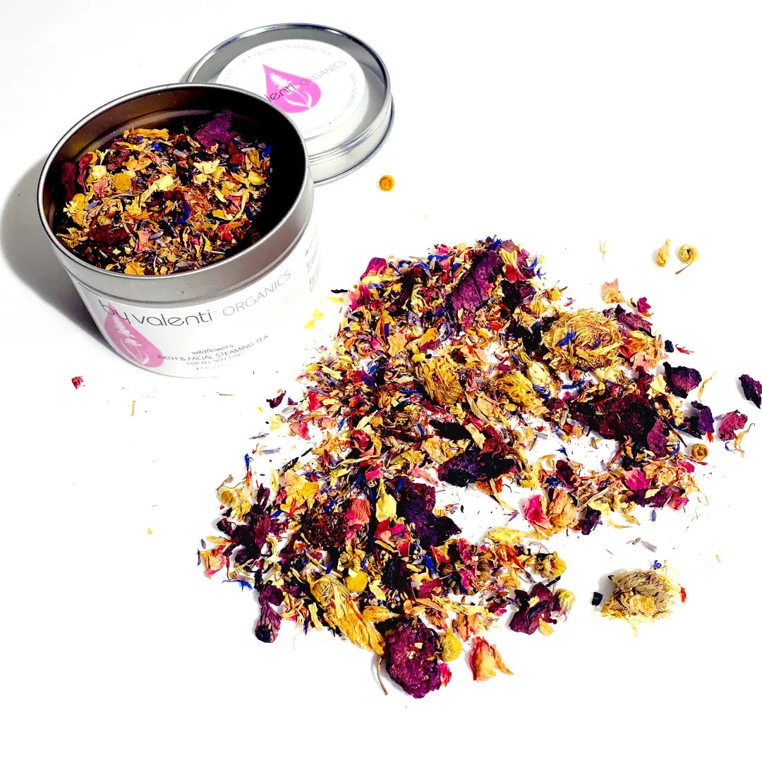Colorful dried flower petals spilling out of a white container with a pink logo and 'BY VALENTI' branding on a white background.