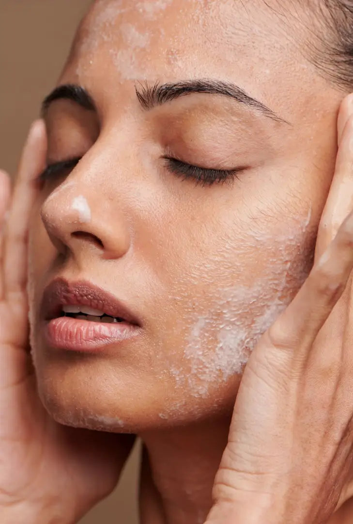 Close-up of a woman applying a skincare product to her face.